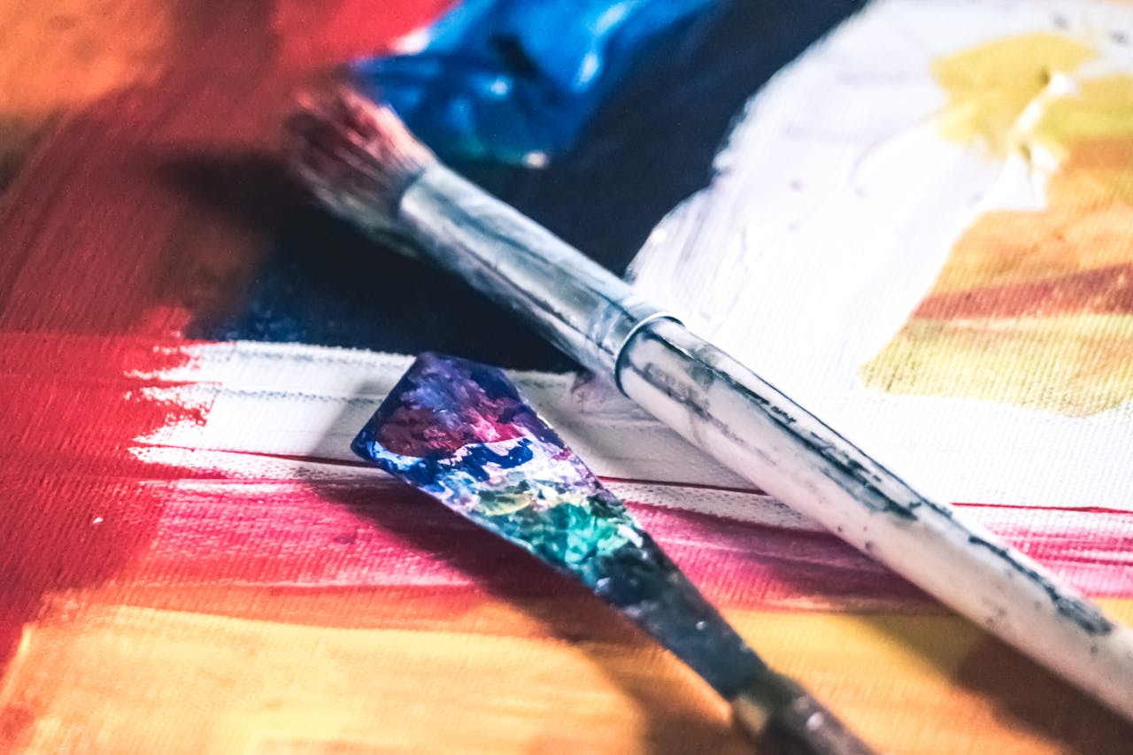 services-03 Close-up of colorful paintbrushes on a vibrant canvas, showcasing creativity and artistic expression.